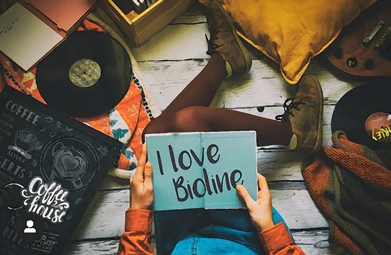 Persona con cartello “I love Bioline” in salotto vintage.