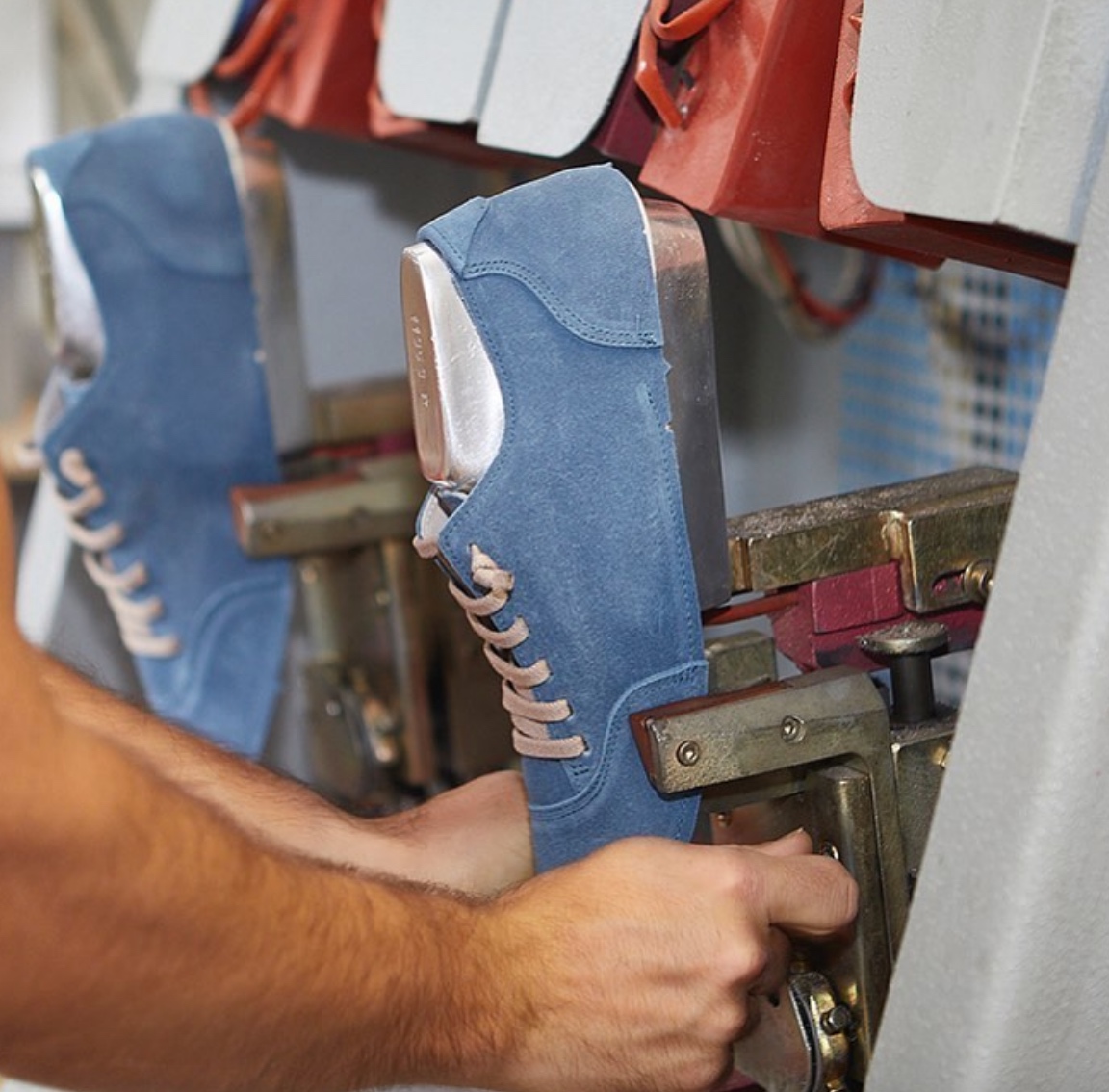 Scarpe blu su stampo in fase di lavorazione industriale.