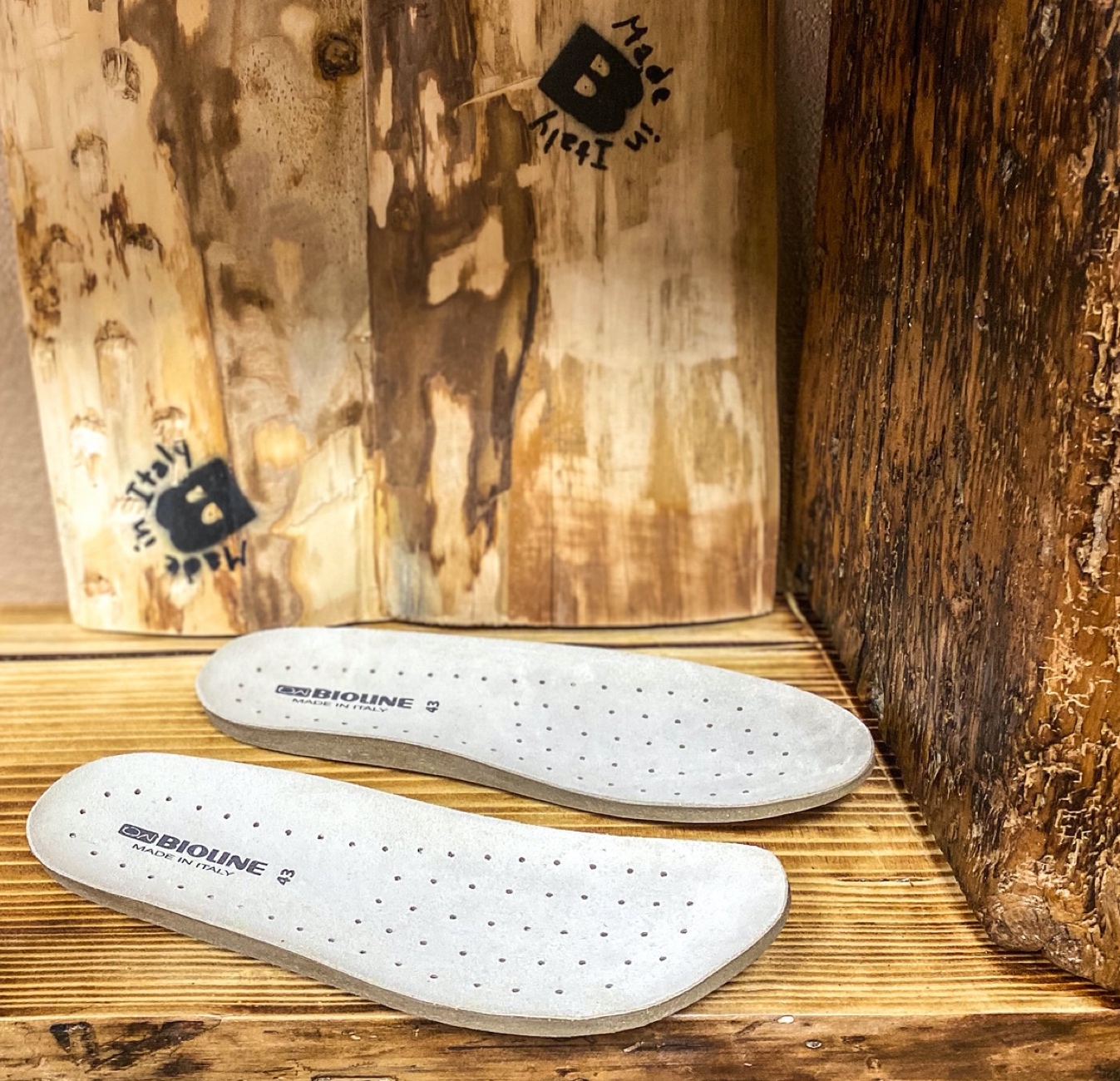 Solette traforate Bioline su fondo di legno con scritte Made in Italy.
