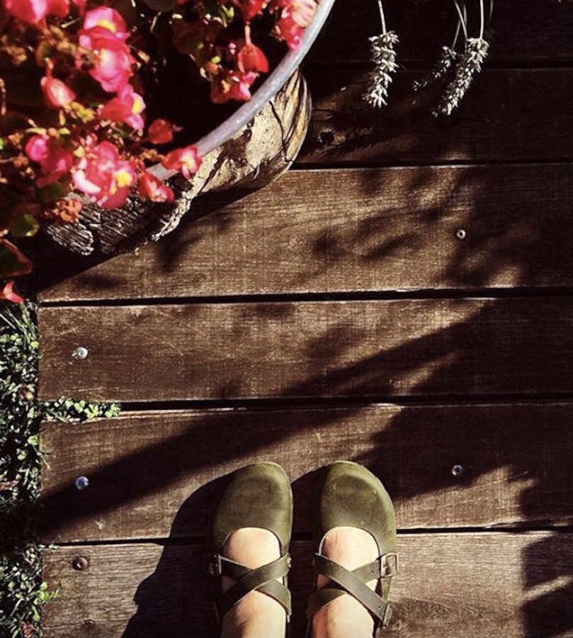 Scarpe verdi con cinturini su terrazza in legno