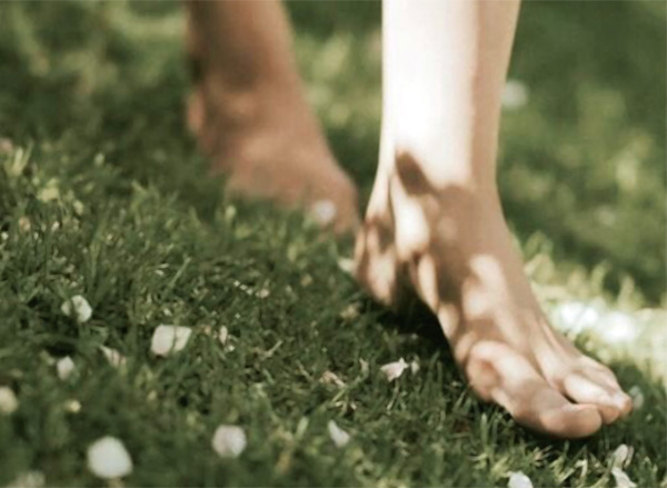 Piedi nudi che camminano sull’erba verde