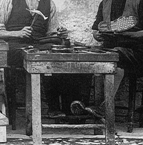Foto storica in bianco e nero di calzolai al lavoro.