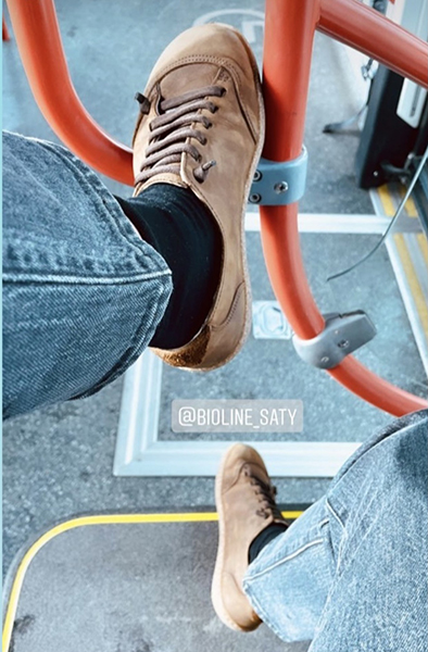Scarpe Bioline marroni indossate su un bus urbano.