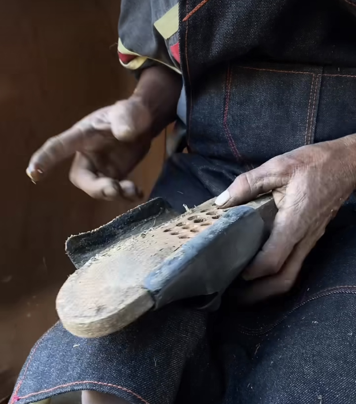 Mani al lavoro su suola durante la produzione artigianale Bioline.