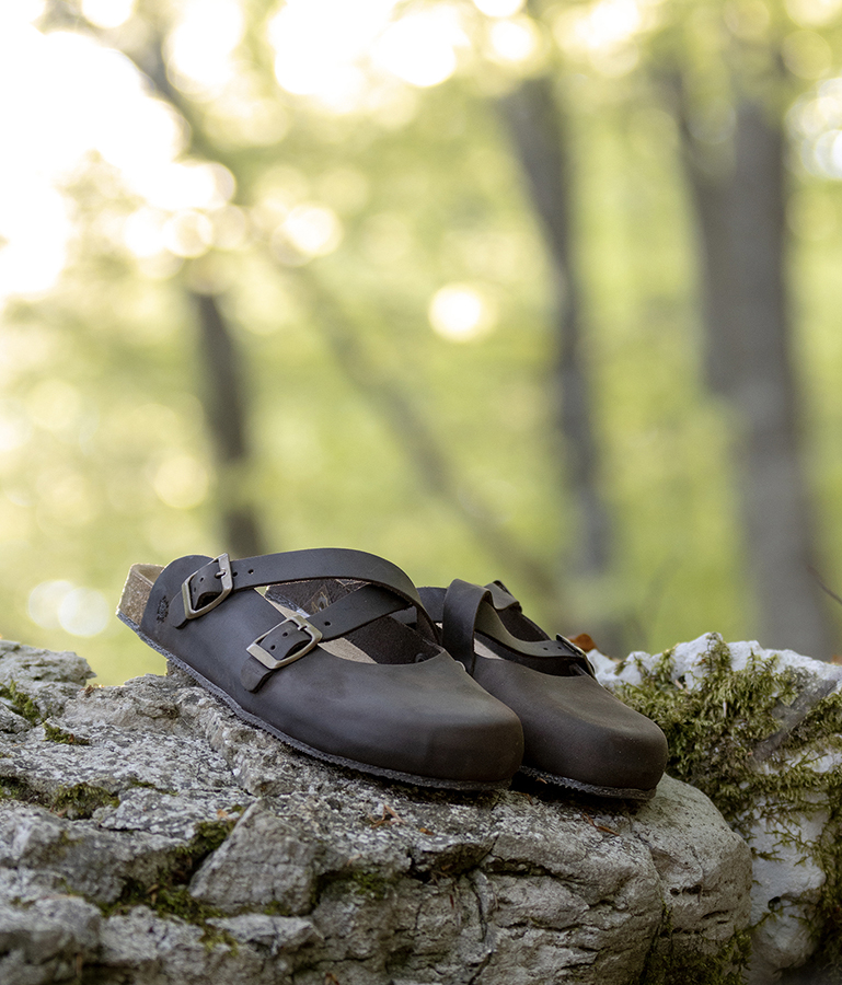Sabot marroni Bioline con doppia fibbia su roccia in bosco.
