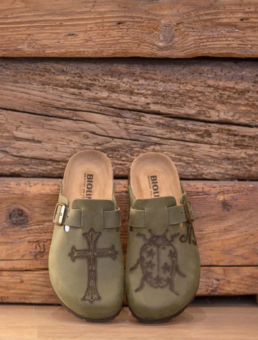 Sabot verde oliva con disegno di croce e scarabeo.